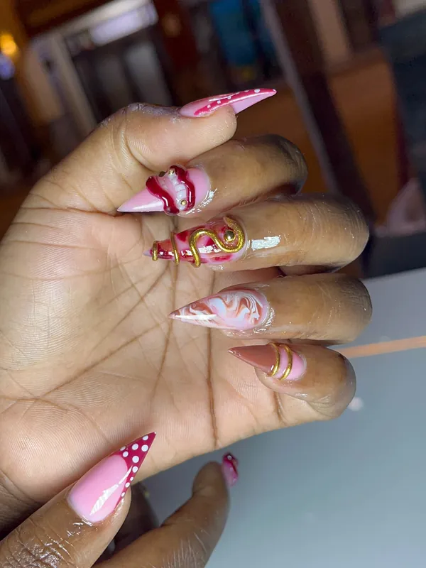 Pink long nails with red and gold designs