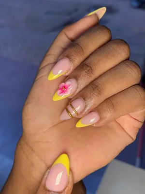 Yellow French tip nails with flower accent